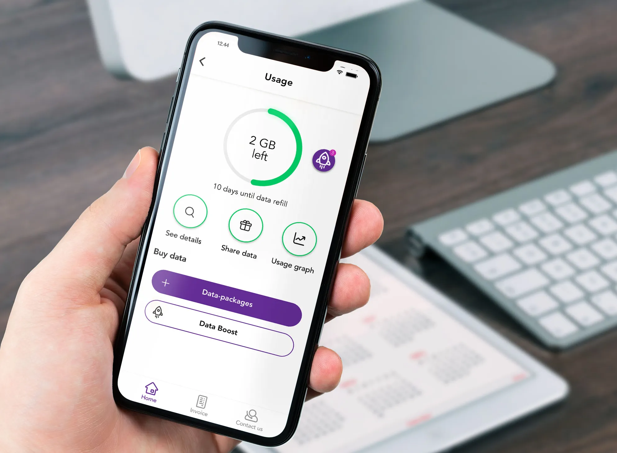 En hånd som holder en mobil med forbrukssiden i Telia-appen