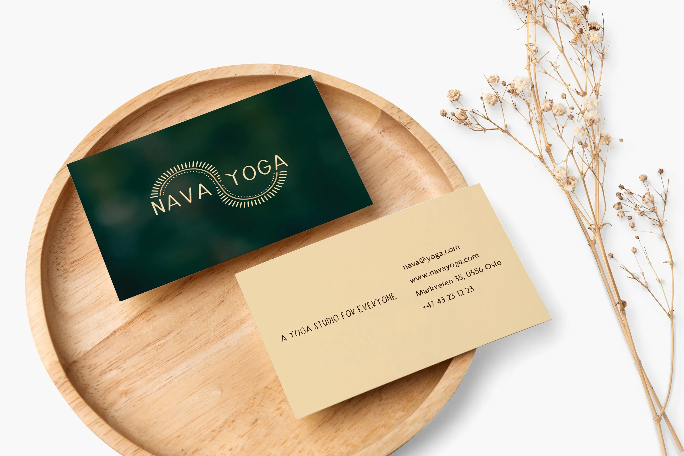 Visittkortene til Nava Yoga på et trefat
